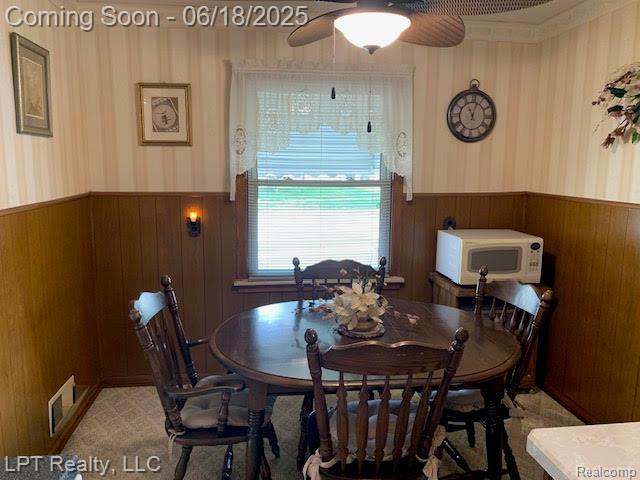 1811 Goddard Rd, Lincoln Park, MI 48146 - dining area with a wainscoted wall, wallpapered walls, wood walls, and ceiling fan