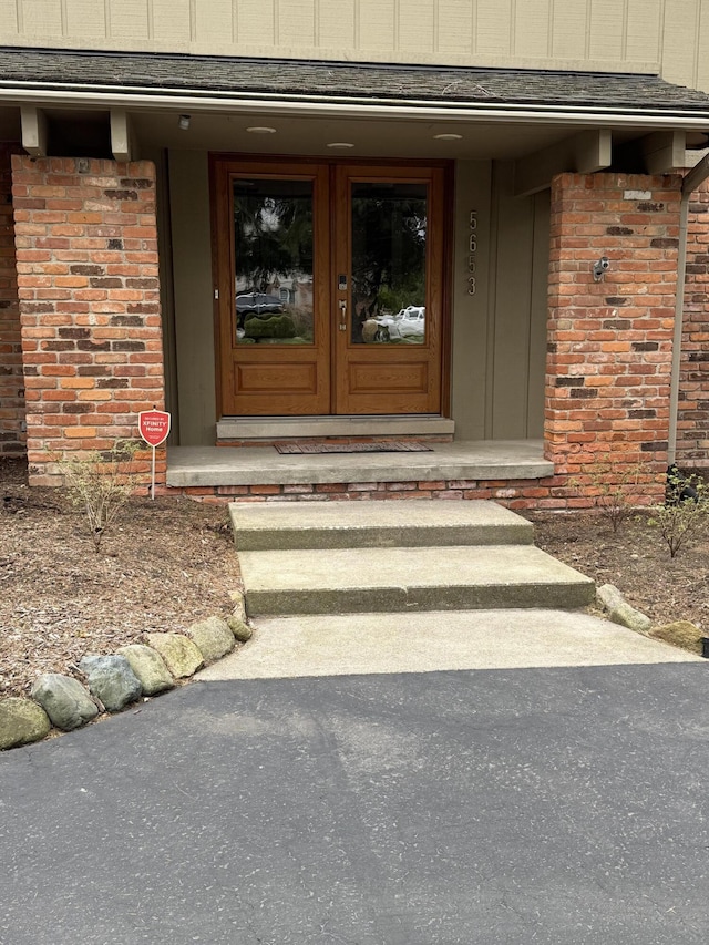 5653 Powder Horn Dr, West Bloomfield, MI 48322 - doorway to property with brick siding, board and batten siding, and french doors