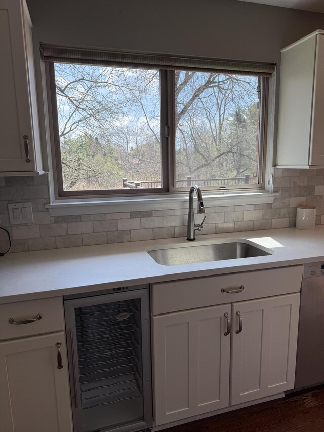 5653 Powder Horn Dr, West Bloomfield, MI 48322 - kitchen with beverage cooler, white cabinets, light countertops, and dishwasher