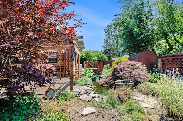 16251 Prest St, Detroit, MI 48235 - view of yard with a storage shed, a wooden deck, and a garden pond