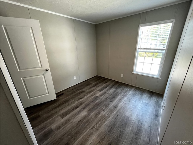 1048 Pheasant Dr, Bay City, MI 48706 - spare room with dark wood-style floors, a decorative wall, and a textured ceiling