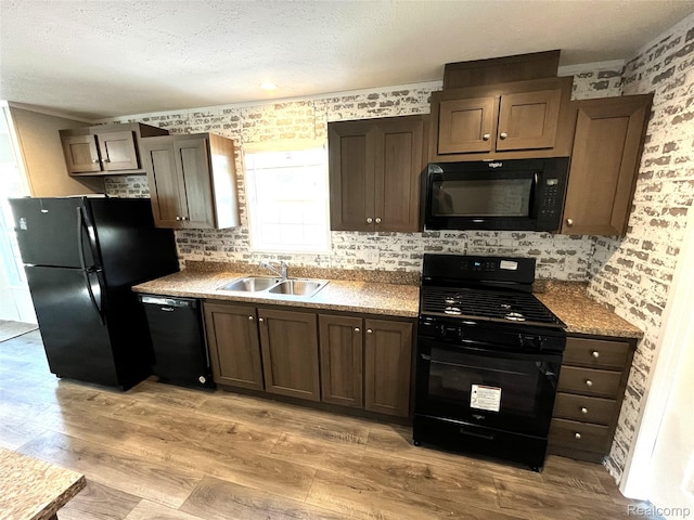 1048 Pheasant Dr, Bay City, MI 48706 - kitchen with black appliances, light wood finished floors, a textured ceiling, decorative backsplash, and dark brown cabinets