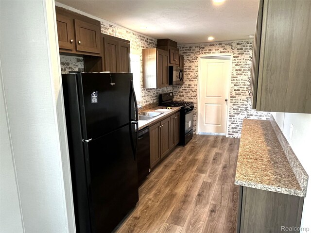1048 Pheasant Dr, Bay City, MI 48706 - kitchen with black appliances, wood finished floors, and dark brown cabinetry