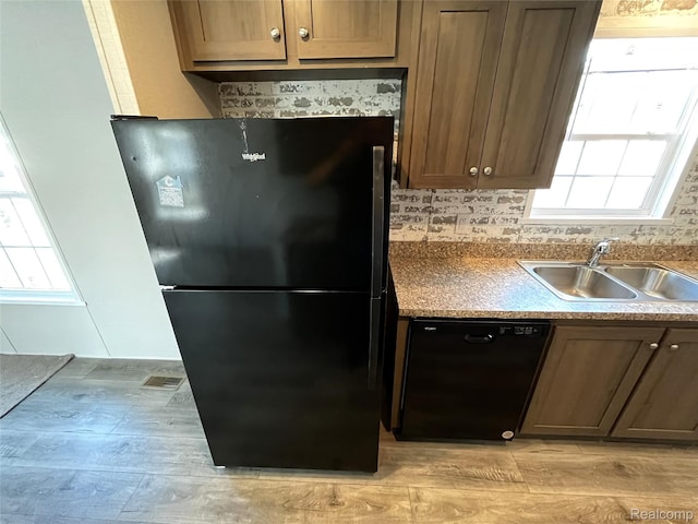 1048 Pheasant Dr, Bay City, MI 48706 - kitchen featuring black appliances, healthy amount of natural light, and light wood-type flooring