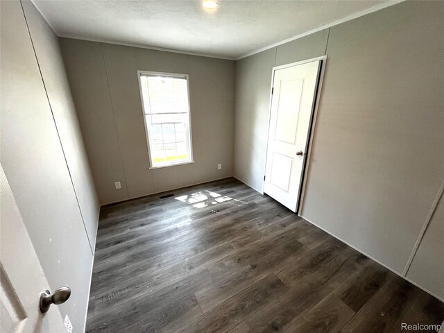 1048 Pheasant Dr, Bay City, MI 48706 - spare room featuring dark wood-style flooring and ornamental molding