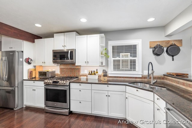 1142 Orchard Ave SE, Grand Rapids, MI 49506 - kitchen featuring appliances with stainless steel finishes, white cabinets, dark stone counters, tasteful backsplash, and dark wood-style floors