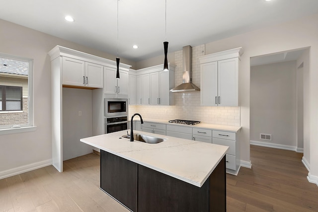 7479 Gramercy Cir W, Bloomfield, MI 48322 - kitchen with wall chimney range hood, appliances with stainless steel finishes, light wood-style floors, decorative backsplash, and recessed lighting