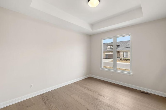 7479 Gramercy Cir W, Bloomfield, MI 48322 - empty room featuring a tray ceiling and wood finished floors