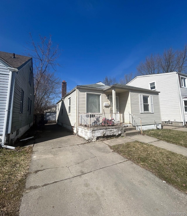 11701 Forrer St, Detroit, MI 48227 - view of front facade with covered porch, a chimney, and driveway