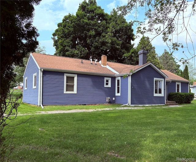 620 Wilmot St, Vassar, MI 48768 - rear view of property featuring a chimney and a lawn