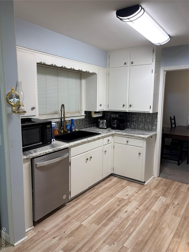 620 Wilmot St, Vassar, MI 48768 - kitchen with stainless steel dishwasher, black microwave, light wood-type flooring, and white cabinetry