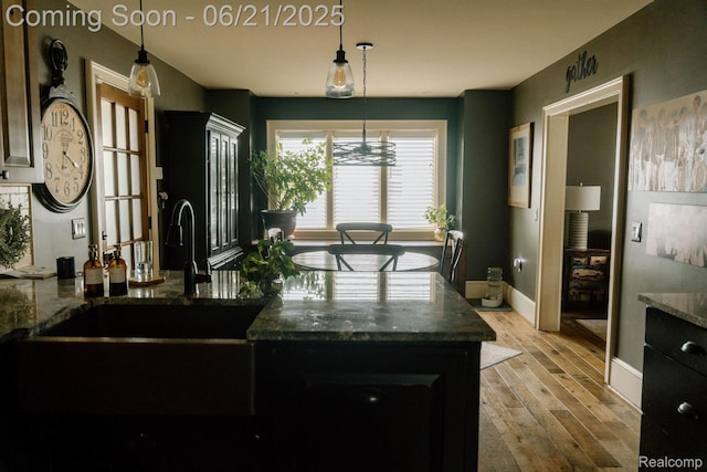 619 E Farnum Ave, Royal Oak, MI 48067 - kitchen featuring light wood-type flooring, hanging light fixtures, and dark stone countertops