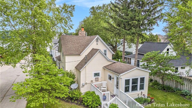 1194 Beach Dr, Holland, MI 49423 - back of property featuring a chimney and a shingled roof