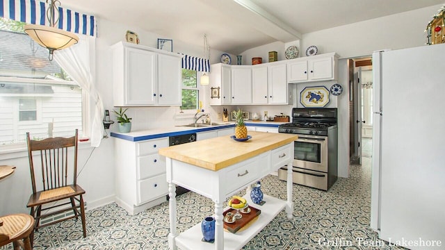 1194 Beach Dr, Holland, MI 49423 - kitchen featuring stainless steel range with gas cooktop, freestanding refrigerator, butcher block countertops, white cabinets, and light flooring