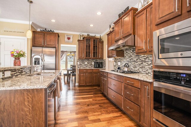 7990 Hemel Ln, Richland, MI 49083 - kitchen with appliances with stainless steel finishes, under cabinet range hood, crown molding, decorative backsplash, and wood finished floors