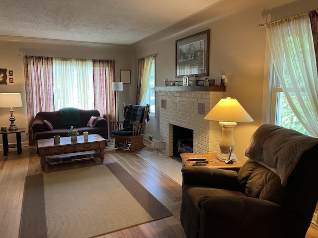 261 W Main St, Hart, MI 49420 - living room featuring a brick fireplace, wood finished floors, and a textured ceiling
