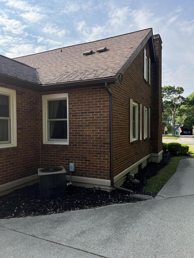 261 W Main St, Hart, MI 49420 - view of home's exterior featuring brick siding, a shingled roof, and a chimney