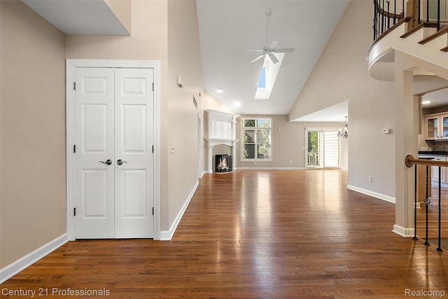 4013 Ardsley Ct, Clarkston, MI 48348 - unfurnished living room featuring a ceiling fan, wood finished floors, a skylight, high vaulted ceiling, and a fireplace
