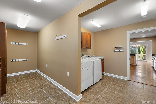 4013 Ardsley Ct, Clarkston, MI 48348 - laundry area with cabinet space, washing machine and clothes dryer, tile patterned floors, and a chandelier