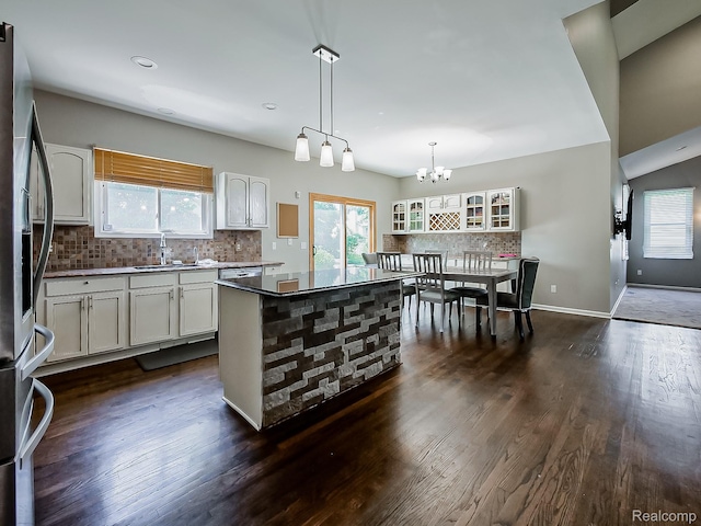 8595 Eastway Dr, White Lake, MI 48386 - kitchen with stainless steel fridge, backsplash, dark wood-style flooring, and white cabinetry