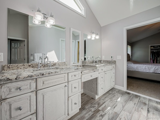 8595 Eastway Dr, White Lake, MI 48386 - full bath with double vanity, wood finished floors, and high vaulted ceiling