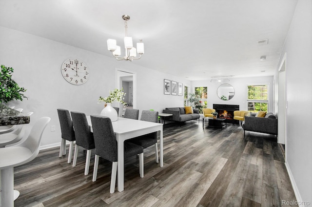 28139 Carlton Way Dr, Novi, MI 48377 - dining room with a chandelier, dark wood-type flooring, and a warm lit fireplace