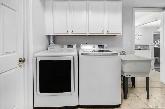 28139 Carlton Way Dr, Novi, MI 48377 - washroom featuring cabinet space, washing machine and clothes dryer, and light tile patterned floors