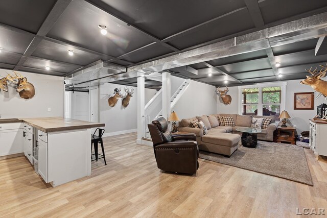13936 Allen Rd, Clinton, MI 49236 - living area featuring coffered ceiling, light wood-style floors, and stairway