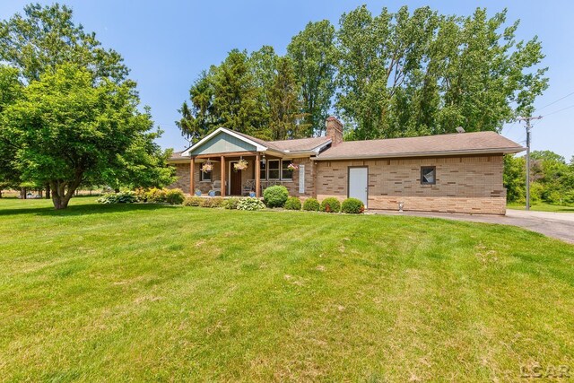 13936 Allen Rd, Clinton, MI 49236 - ranch-style home featuring brick siding, a porch, a front lawn, and a chimney