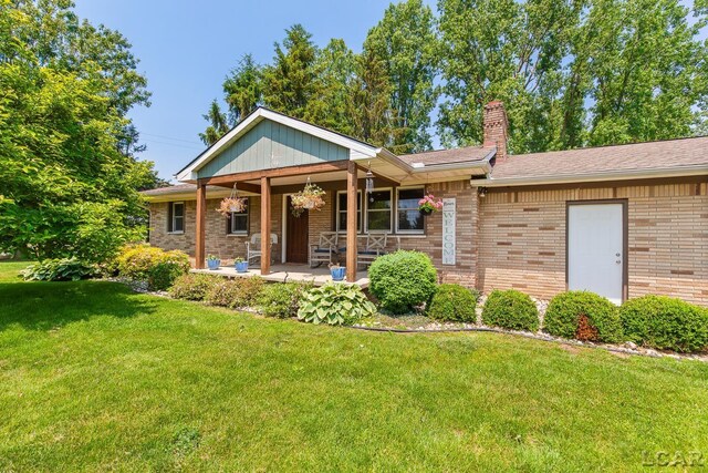 13936 Allen Rd, Clinton, MI 49236 - ranch-style home featuring a front lawn, a chimney, brick siding, and a porch