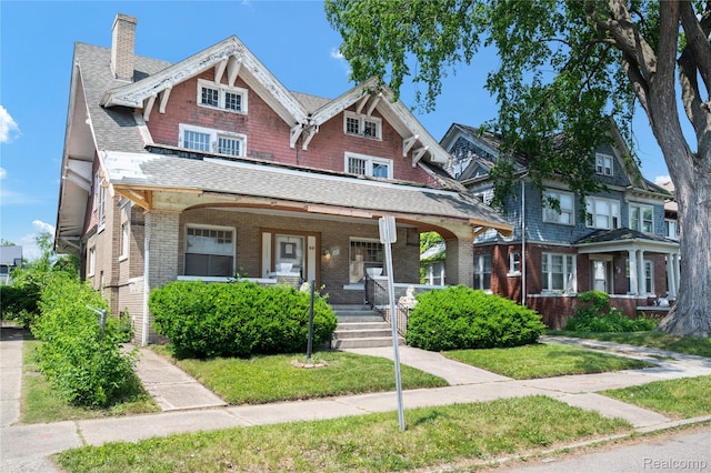 69 Massachusetts St, Highland Park, MI 48203 - view of front of house featuring a porch, a chimney, brick siding, and roof with shingles
