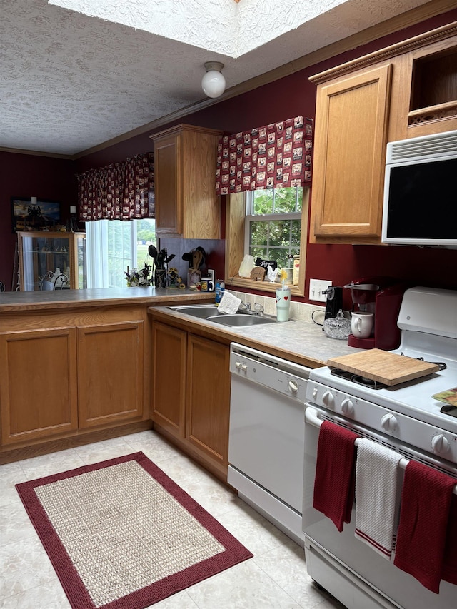9233 Gary Rd, Chesaning, MI 48616 - kitchen featuring white appliances, a textured ceiling, brown cabinetry, and light countertops