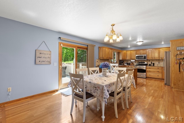 838 Stetson St, Tecumseh, MI 49286 - dining area with light wood-style flooring and a chandelier