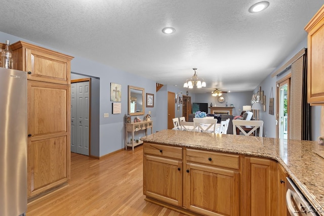 838 Stetson St, Tecumseh, MI 49286 - kitchen with stainless steel appliances, a chandelier, a peninsula, light wood-style floors, and open floor plan