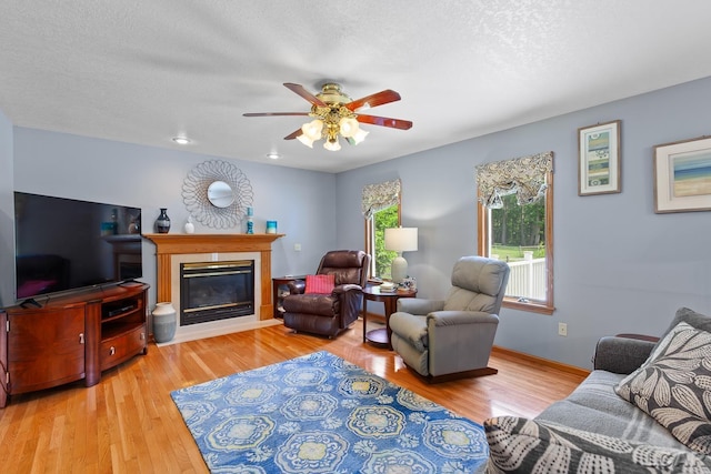 838 Stetson St, Tecumseh, MI 49286 - living area with ceiling fan, wood finished floors, a glass covered fireplace, and a textured ceiling