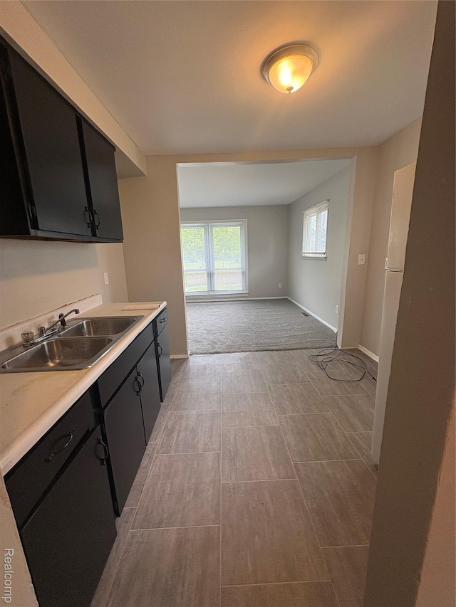 565 Wyoming Ave, Pontiac, MI 48341 - kitchen with dark cabinets, light countertops, open floor plan, and light colored carpet