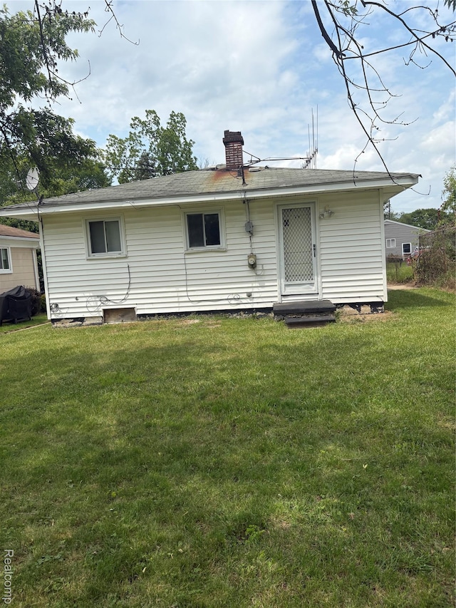 565 Wyoming Ave, Pontiac, MI 48341 - back of property featuring a lawn and a chimney