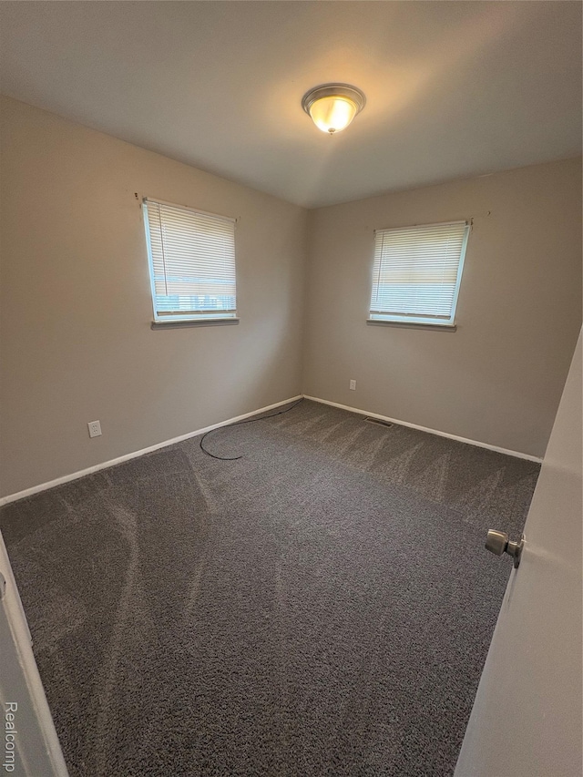 565 Wyoming Ave, Pontiac, MI 48341 - empty room with dark carpet and baseboards