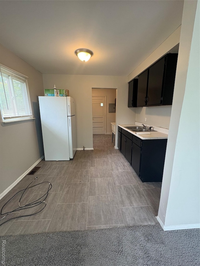 565 Wyoming Ave, Pontiac, MI 48341 - kitchen featuring freestanding refrigerator, dark cabinetry, and light countertops