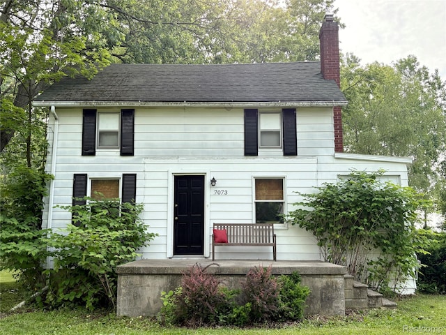 7073 N Linden Rd, Mount Morris, MI 48458 - view of front facade with a chimney and covered porch
