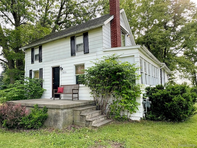7073 N Linden Rd, Mount Morris, MI 48458 - view of front of property featuring a chimney and a front lawn