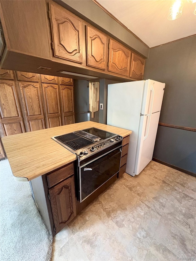 7073 N Linden Rd, Mount Morris, MI 48458 - kitchen with electric range oven, freestanding refrigerator, light countertops, and brown cabinetry