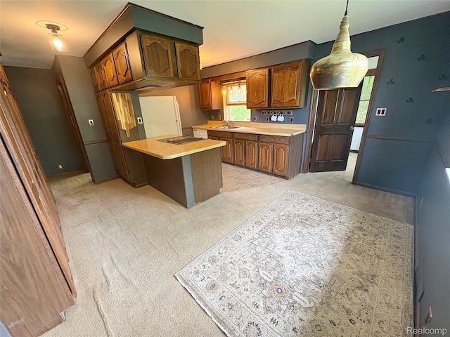 7073 N Linden Rd, Mount Morris, MI 48458 - kitchen featuring brown cabinetry, stovetop, light carpet, hanging light fixtures, and wooden counters