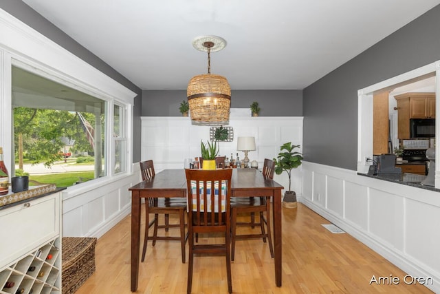 307 N Jefferson St SE, Lowell, MI 49331 - dining space with a decorative wall, light wood finished floors, and wainscoting