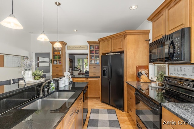 307 N Jefferson St SE, Lowell, MI 49331 - kitchen featuring black appliances, decorative light fixtures, light wood-type flooring, glass insert cabinets, and dark stone countertops