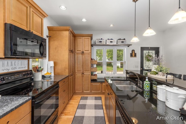 307 N Jefferson St SE, Lowell, MI 49331 - kitchen featuring black appliances, light wood-style flooring, hanging light fixtures, recessed lighting, and dark stone counters