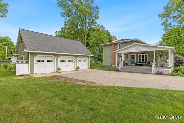 307 N Jefferson St SE, Lowell, MI 49331 - view of front of home featuring covered porch, a front yard, a detached garage, a chimney, and an outbuilding