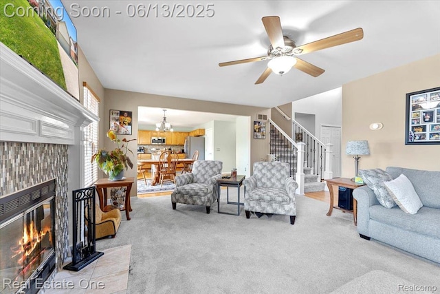 26957 Blue Heron Dr, Flat Rock, MI 48134 - living room with stairs, light carpet, ceiling fan, a chandelier, and a tile fireplace