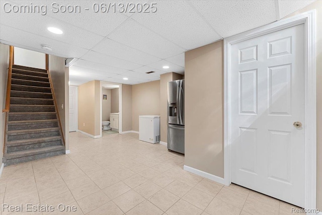 26957 Blue Heron Dr, Flat Rock, MI 48134 - finished basement featuring stainless steel refrigerator with ice dispenser, stairway, fridge, light tile patterned floors, and a drop ceiling