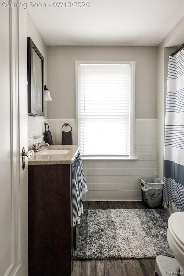 3924 Yorkshire Rd, Detroit, MI 48224 - bathroom featuring tile walls, vanity, wood finished floors, a wainscoted wall, and radiator